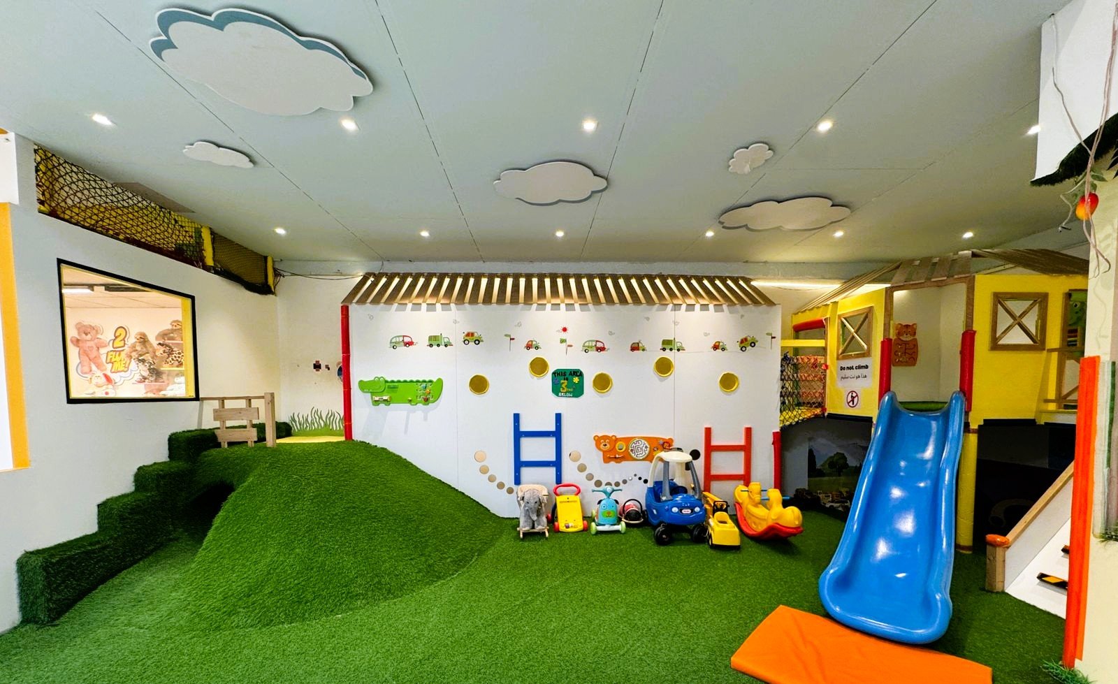 Toddler soft play and slide area at Gogo Village Dubai, featuring a mini playhouse, safe climbing stairs, trampoline section, and padded flooring for young children.